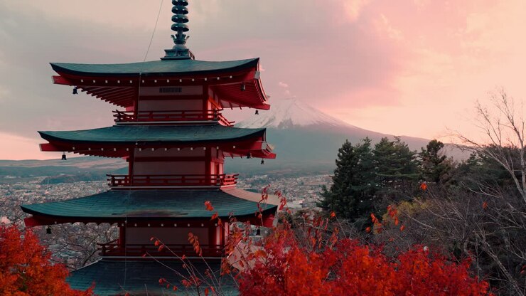 Enchanting view of Chureito Pagoda framed by vivid red autumn foliage during peak momiji season, with Mount Fuji majestically rising in the background.
