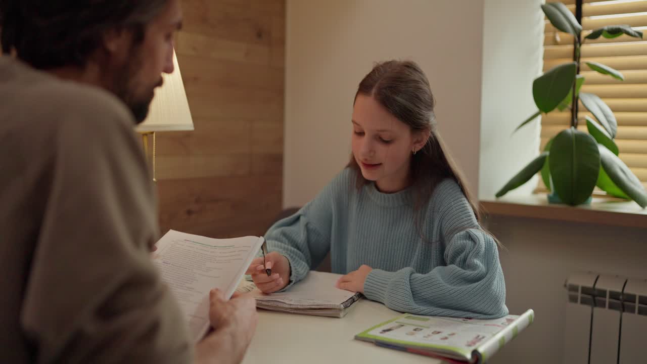 Girl doing homework with her father