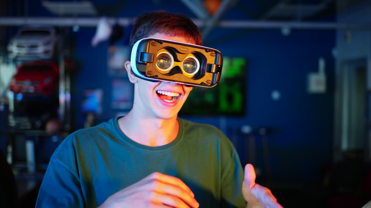 Giovane ingegnere con visore VR per la realtà virtuale che si diverte e balla in un laboratorio di ricerca