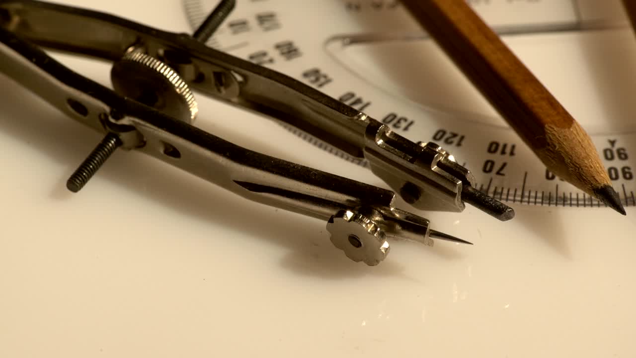 primer plano de un conjunto de brújulas y un lápiz