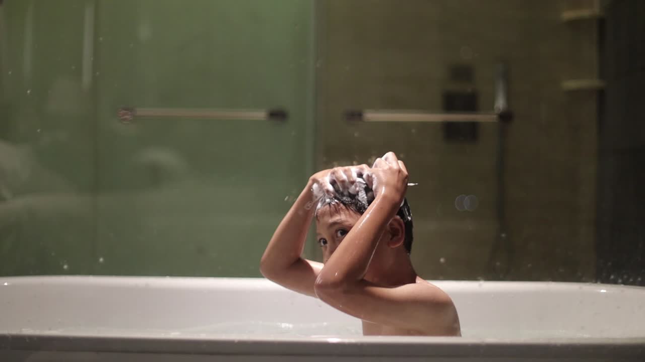 Asian boy is shampooing on the bathtub