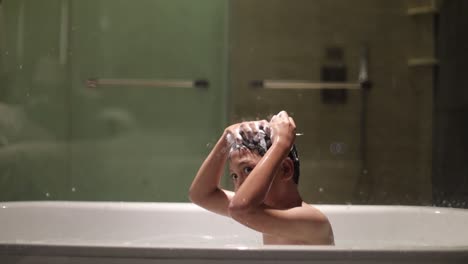asian boy is shampooing on the bathtub