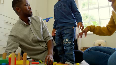 low angle view of young black family playing and sitting on the floor of comfortable home 4k