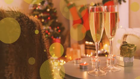 Animation-of-yellow-spots-of-light-over-new-year-glasses-of-champagne-and-christmas-tree