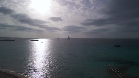 sol redondo, velero en el horizonte