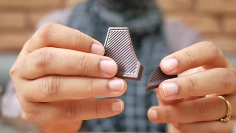 person breaking a piece of dark chocolate