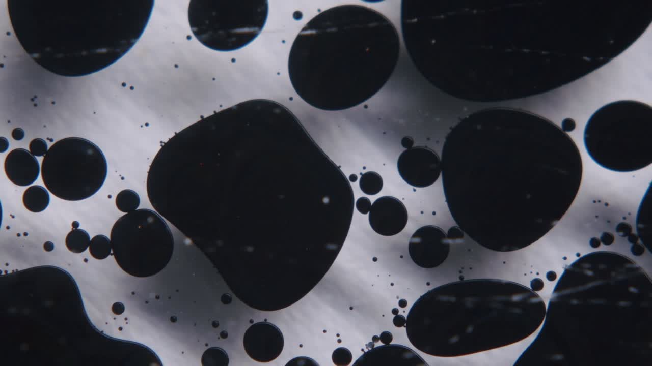 черное масло, образующее абстрактные формы в прозрачной жидкости