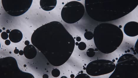 aceite negro formando formas abstractas en un líquido transparente