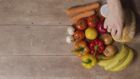 Overhead-Shot-Of-Person-Choosing-From-Fresh-Food-Items-On-Wooden-Surface