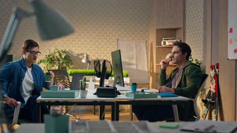 two people communicating workplace interior. positive man drinking tea at office