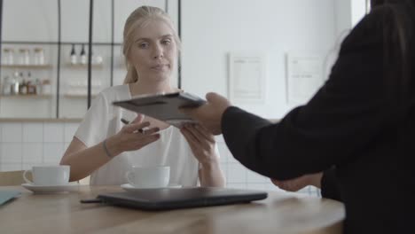 agent and female customer signing health insurance agreement