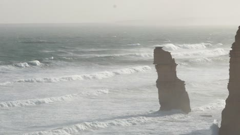 una vista serena de las formaciones rocosas de los doce apóstoles contra las olas estrelladas y la suave luz de la tarde a lo largo de la gran carretera oceánica de australia