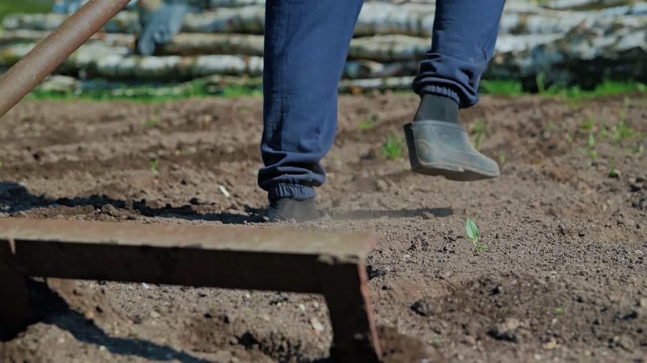Momento auténtico de estilo de vida rural que muestra los zapatos de un agricultor y el trabajo del suelo en primavera