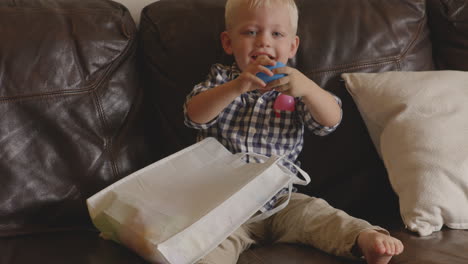 slow motion shot of a young, blonde boy playing with a blue easter egg