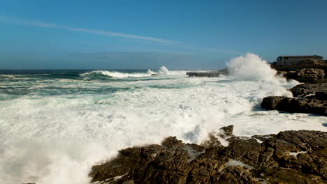 wave crashes and runs onto rocks of rocky coastline