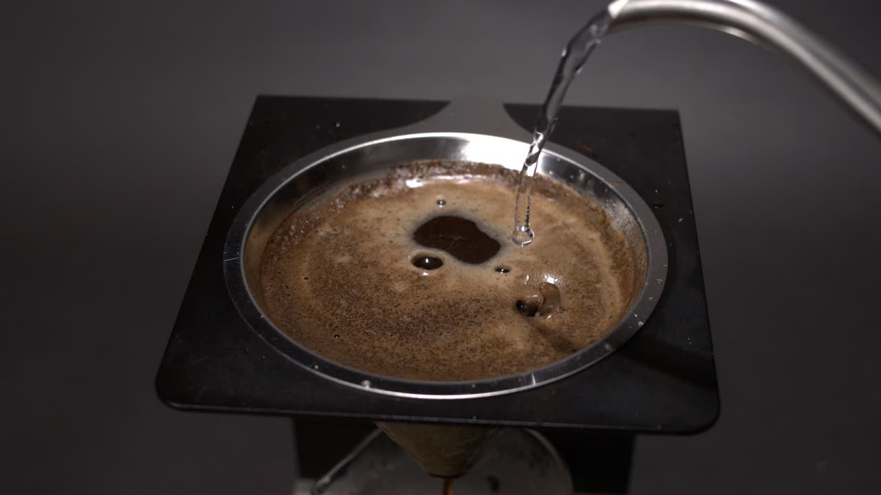 pouring water into a coffee maker in super slow motion