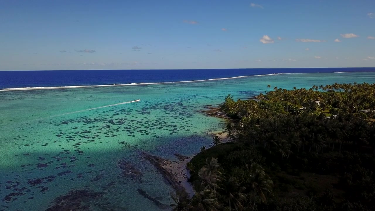 Luftfoto fra drone af Fransk Polynesien, der viser turkise lagunevande, hvide sandstrande og frodige palmeskove mod grønne vulkanske bjerge. Øerne Bora Bora, Huahine, Tahiti, Rangiroa.