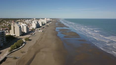 aerial drone view going up of empty beach with low tide, in monte hermoso, argentina