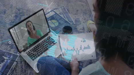 man sitting cross-legged in home office attending remote business call, showing animated bar charts