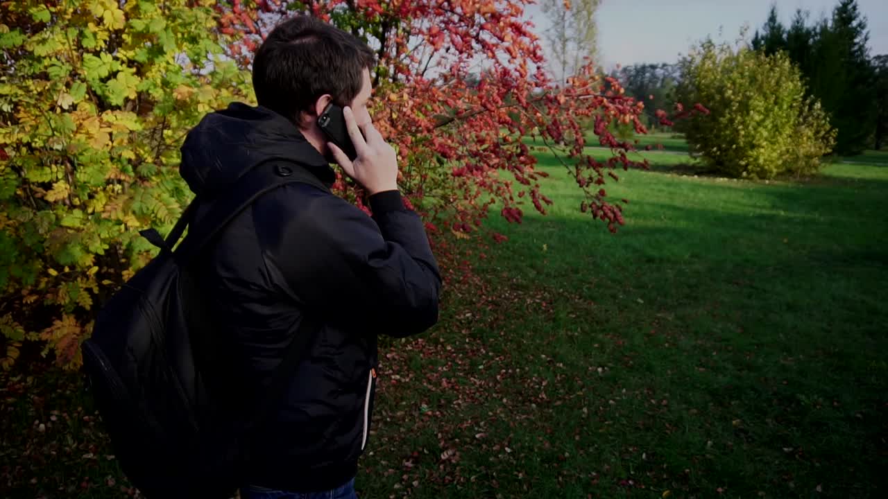Man Talking on Phone in Autumn Park