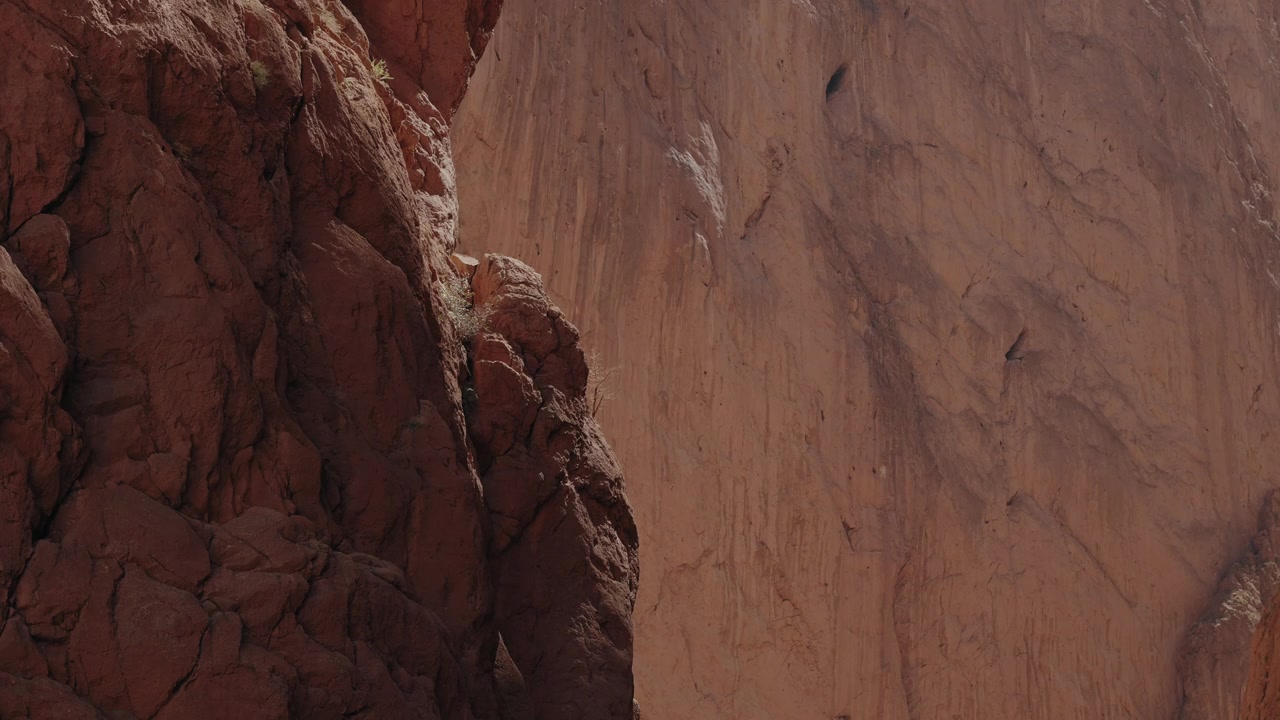 Imponenti pareti di canyon in calcare rosso con una texture rocciosa aspra nella Gola del Todgha a Tinghir, Marocco