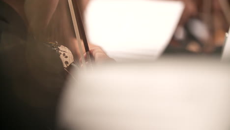man playing violin while looking at sheet music