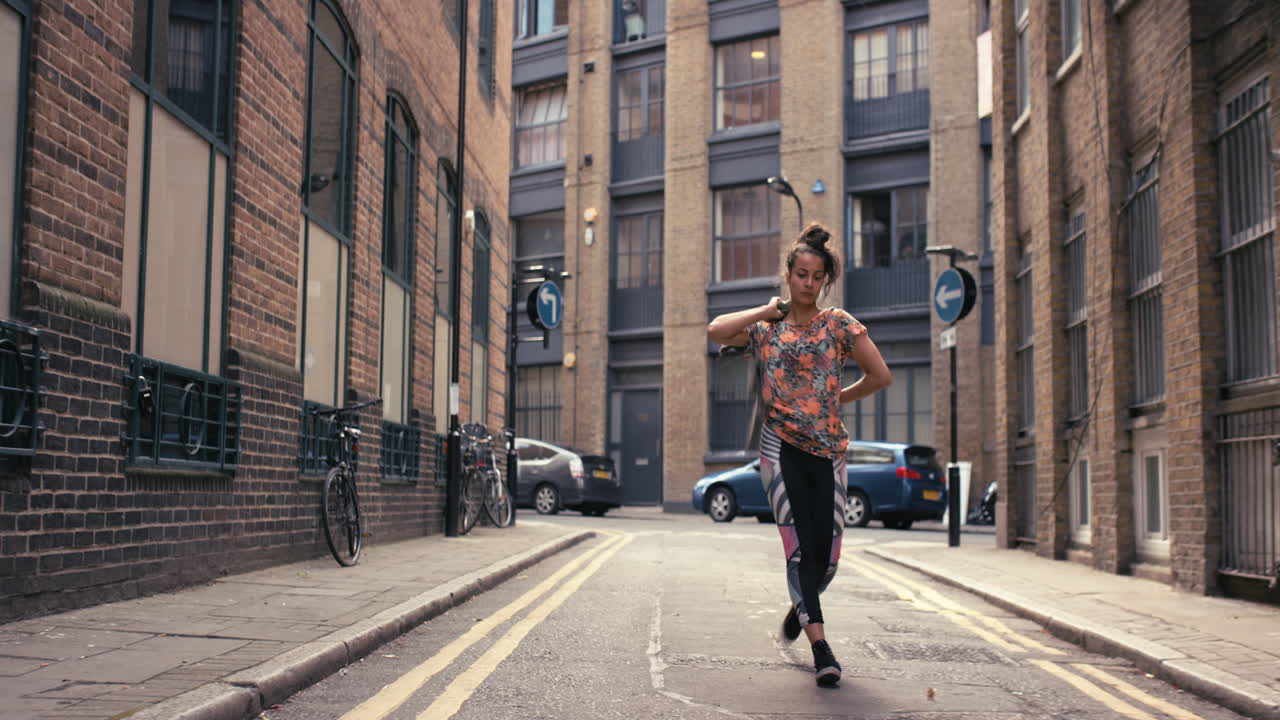 Contemporary funky mixed race woman street dancer dancing freestyle in the city