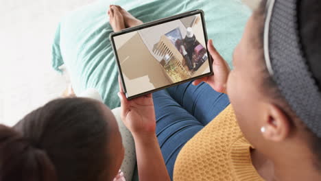 African-american-mother-and-daughter-using-tablet,-online-shopping-for-beauty-products,-slow-motion