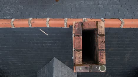 Brick-chimney-on-top-of-private-house-rooftop,-aerial-top-down-view