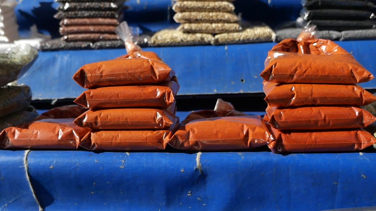 Stacked Bags of Red Paprika and Spices at an Outdoor Market
