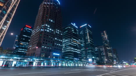 tráfico nocturno cerca del centro de transferencia de autobuses y los edificios de rascacielos de la ciudad en el distrito financiero de yeouido - timalapse estático