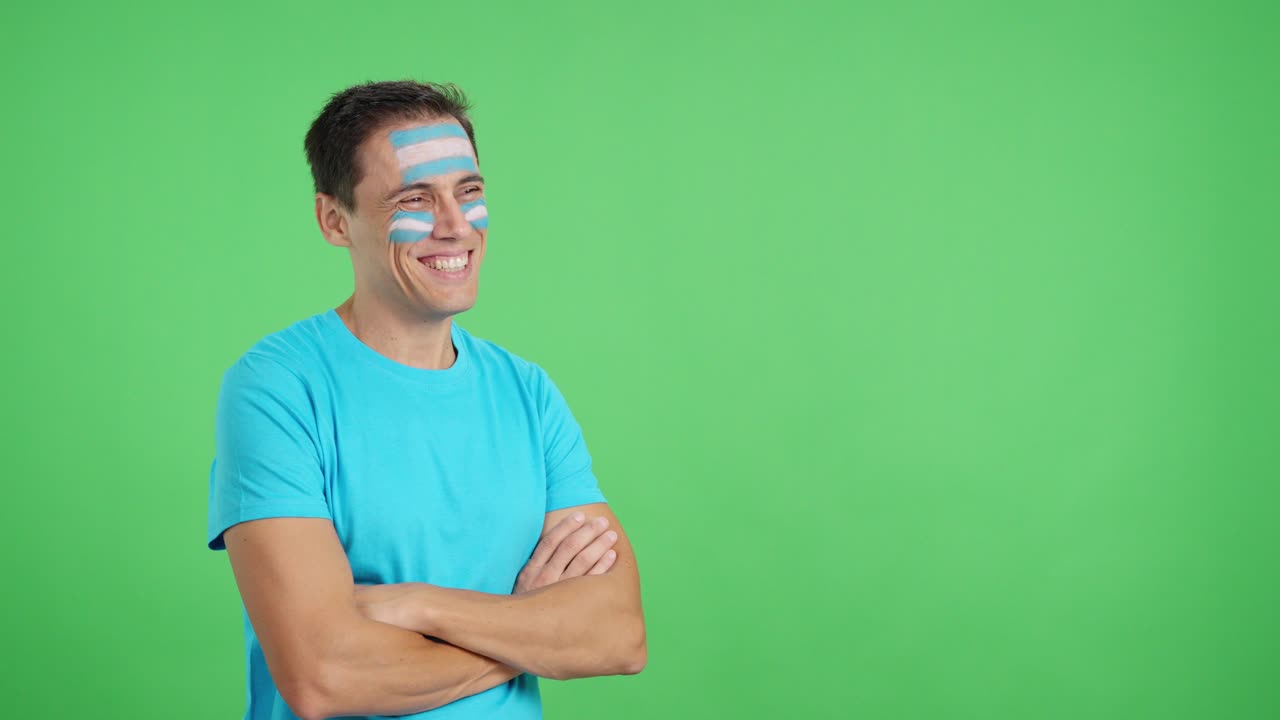Happy man with argentine flag painted on face looking away