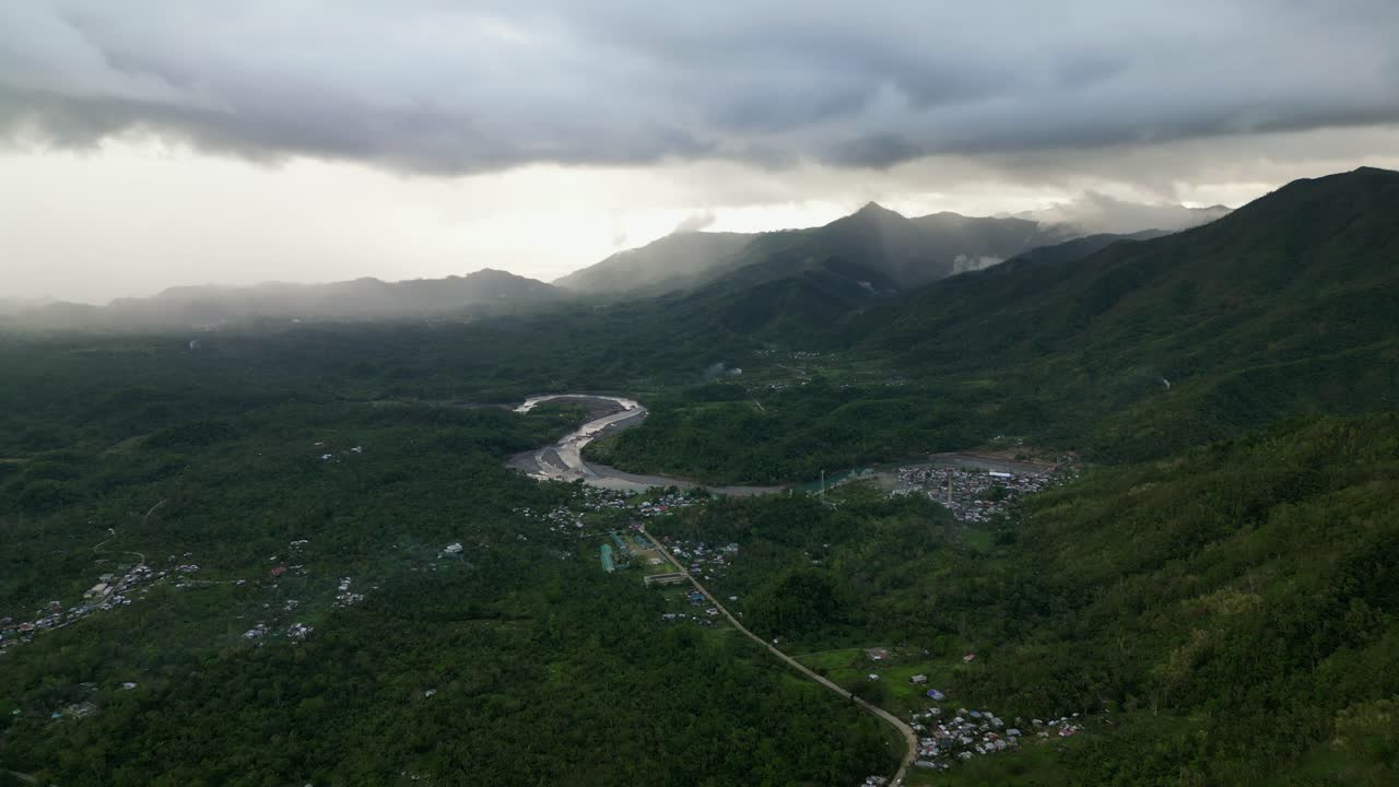 Toàn cảnh trên không nhìn ra một hòn đảo nhiệt đới, núi non tươi tốt dưới bầu trời u ám với những đám mây mưa - Virac, Catanduanes, Philippines