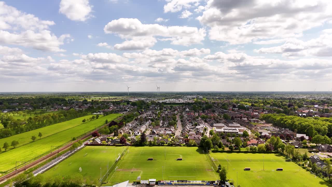 Aerial View of a Dutch Town with Wind Turbines and Soccer Field