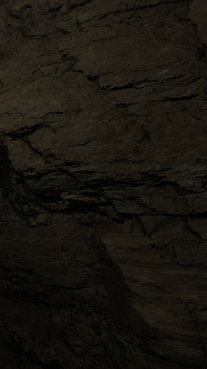 Rock formation inside a cave near a dark entrance showing structure details