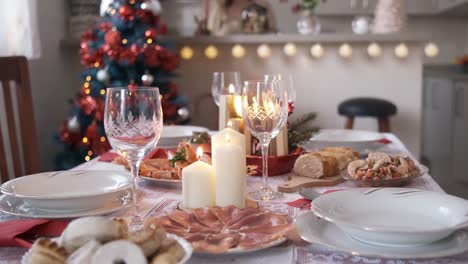 table set to celebrate christmas with food, ornaments and candles