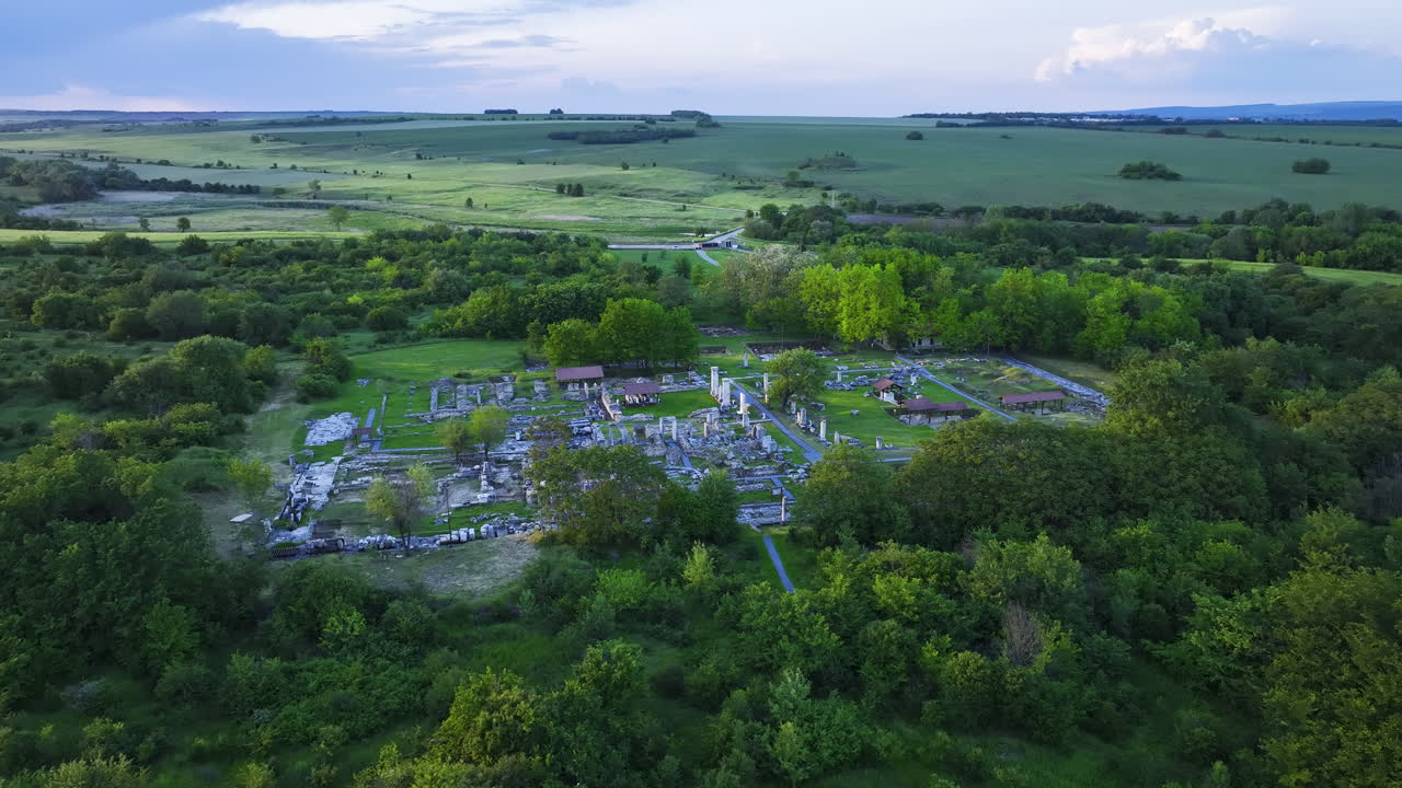 Distant drone view of Nicopolis ad Istrum at golden hour, as the sun illuminates the Roman city ruins