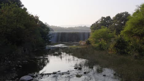 dam-water-overflowing-at-mountains-at-day-from-flat-angle