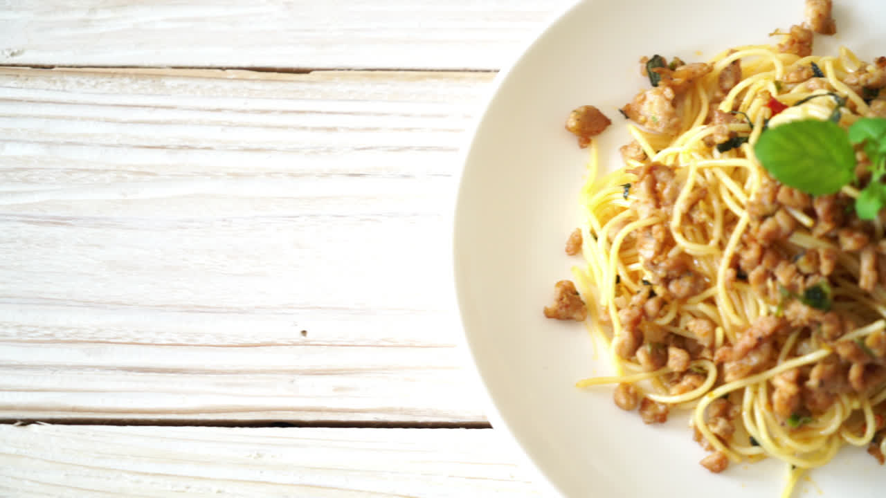 espaguetis picantes salteados con cerdo picado y albahaca