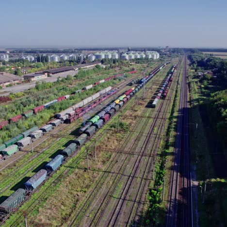 freight train at a rail yard with grain silos