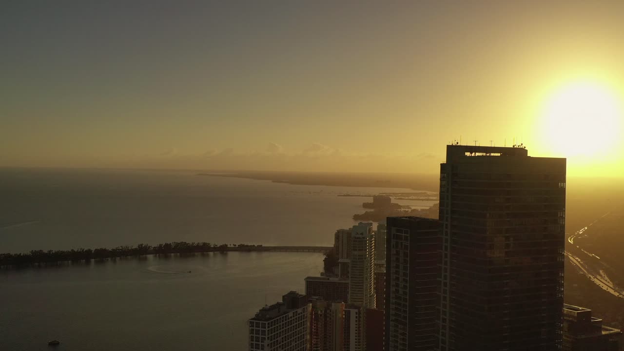 Plano de aproximação cinematográfico de edifício icônico na Brickell Drive em Miami, Flórida, ao pôr do sol durante a hora dourada.