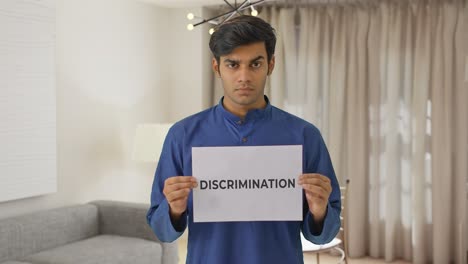 angry indian boy holding discrimination banner