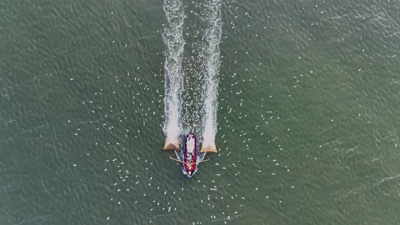 disparo desde arriba de un barco de pescadores arrastrando las redes a través del agua