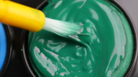 green paint being applied with a brush