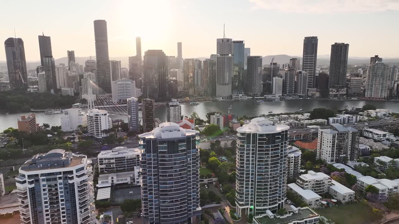 Brisbane cityscape aerial reveal over Kangaroo Point residential to city downtown during sunset.