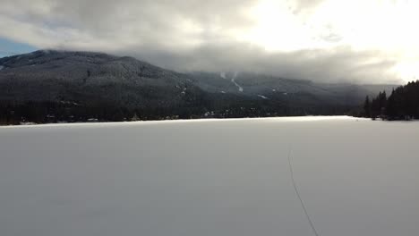 Frozen-Lake-With-Cloudy-Sky-Above-Mountains-During-Winter-In-Whistler,-BC,-Canada