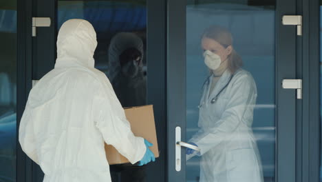 a man in a protective antiviral suit knocks on the door of the house