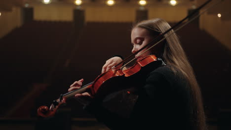 pretty female violinist is playing fiddle in symphonic orchestra portrait of woman musician