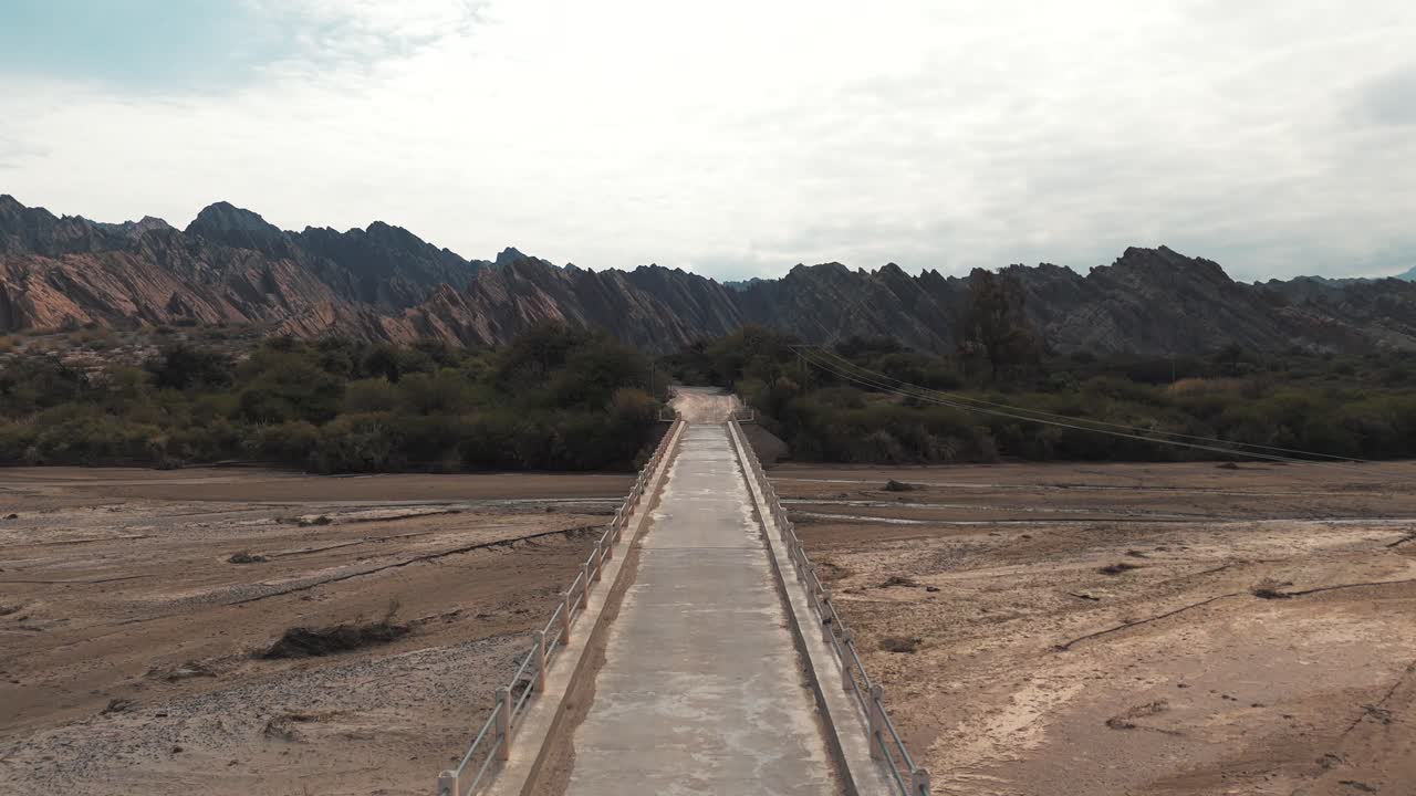 полет беспилотника над узким мостом, пересекающим реку качалки в квебрадасе-де-лас-флечас, провинция сальта, аргентина