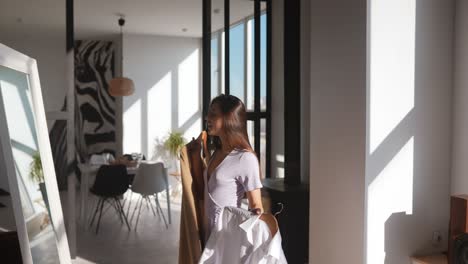 woman trying on clothes in front of a mirror at home